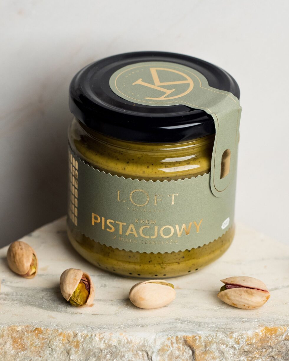 Krem pistacjowy z białą czekoladą w szklanym słoiku na loftowym tle