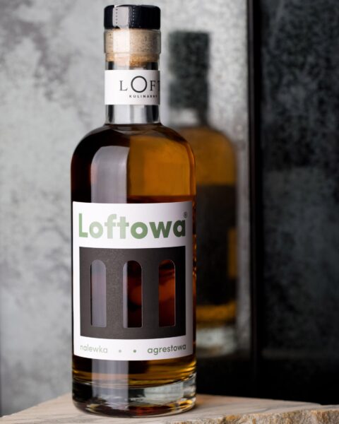 nalewka agrestowa w szklanej butelce 500 ml na loftowym, minimalistycznym tle