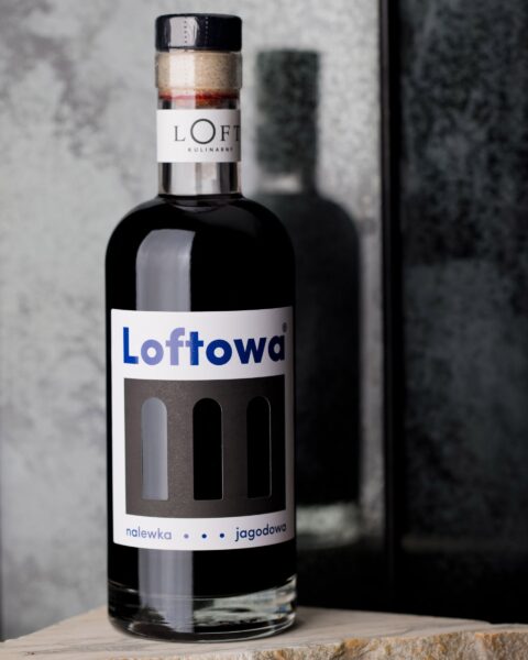 nalewka z jagody kamczackiej w butelce 500 ml o ciemnoczerwonej barwie na loftowym tle