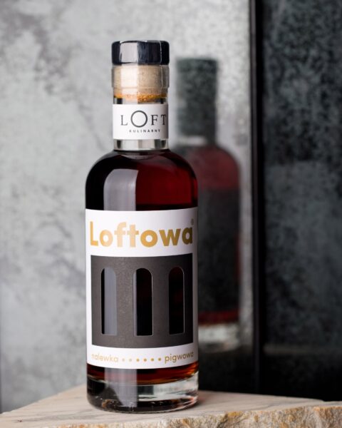 nalewka pigwowa w butelce 350 ml z jasnożółtą barwą na loftowym tle