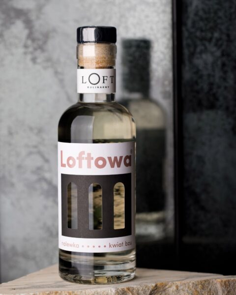 Nalewka z kwiatu bzu w butelce 350 ml o jasnożółtej barwie na loftowym tle