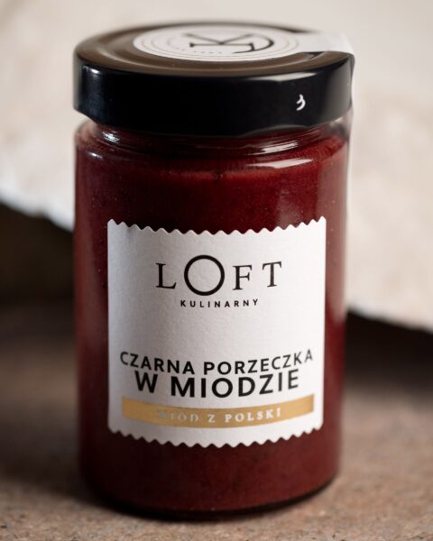 Czarna porzeczka w miodzie w słoiku – owocowy dodatek do deserów na loftowym tle