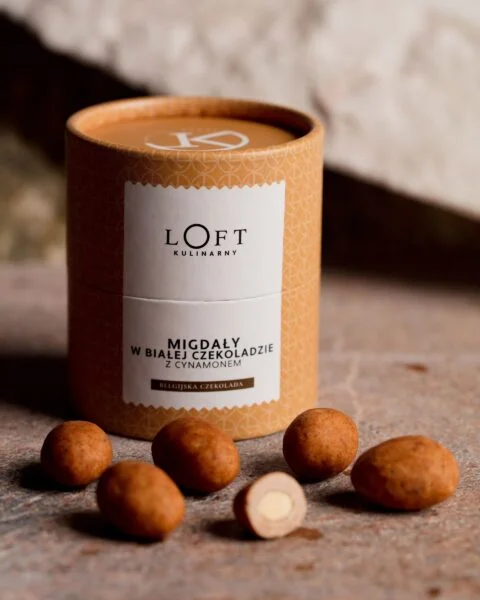migdały w białej czekoladzie z cynamonem w eleganckim opakowaniu na loftowym tle