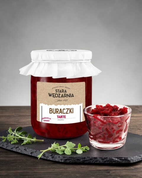 Buraczki tarte Stara Wędzarnia - na czarnym kamiennym talerzu, drewniany stol, szare cementowe tlo, zielone ziola