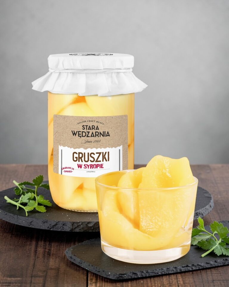 Gruszki w syropie Stara Wędzarnia - na czarnym kamiennym talerzu, drewniany stol, szare cementowe tlo, zielone ziola