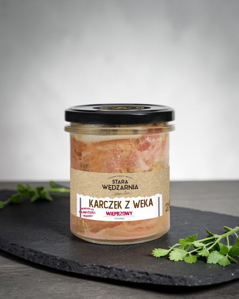 Karczek z weka wieprzowy Stara Wędzarnia - na czarnym kamiennym talerzu, drewniany stol, szare cementowe tlo, zielone ziola