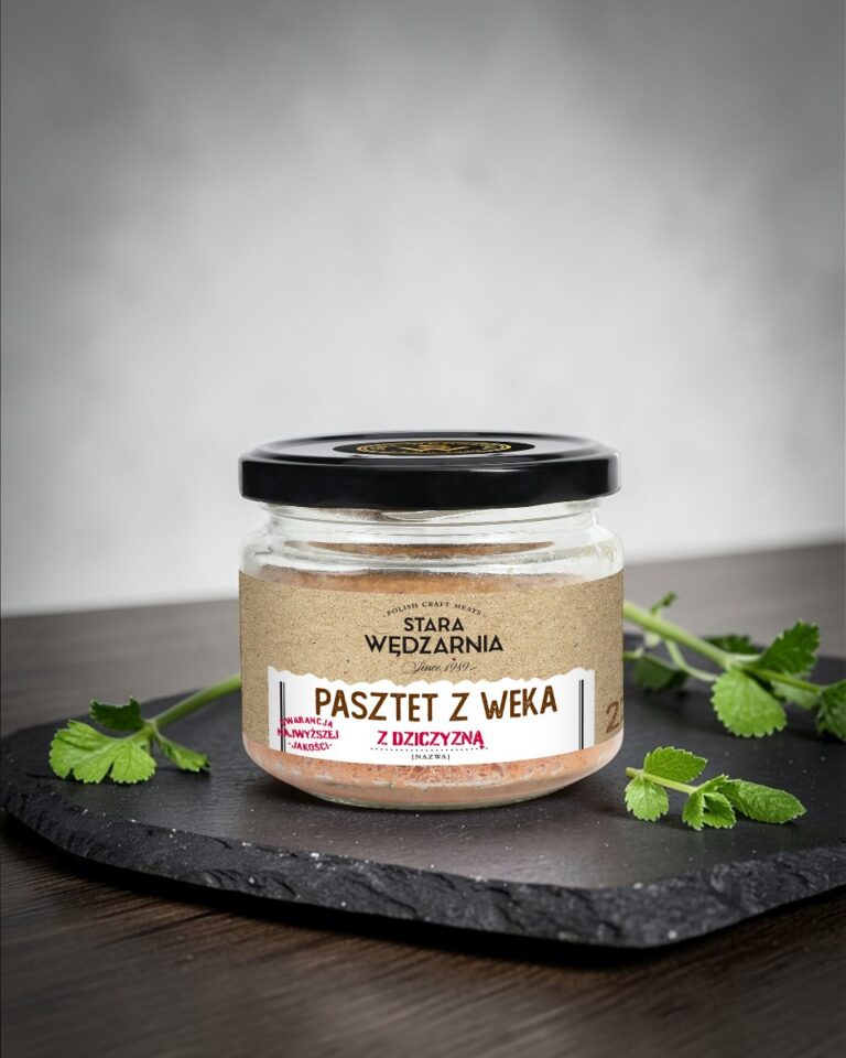 Pasztet z weka z dziczyzną Stara Wędzarnia - na czarnym kamiennym talerzu, drewniany stol, szare cementowe tlo, zielone ziola